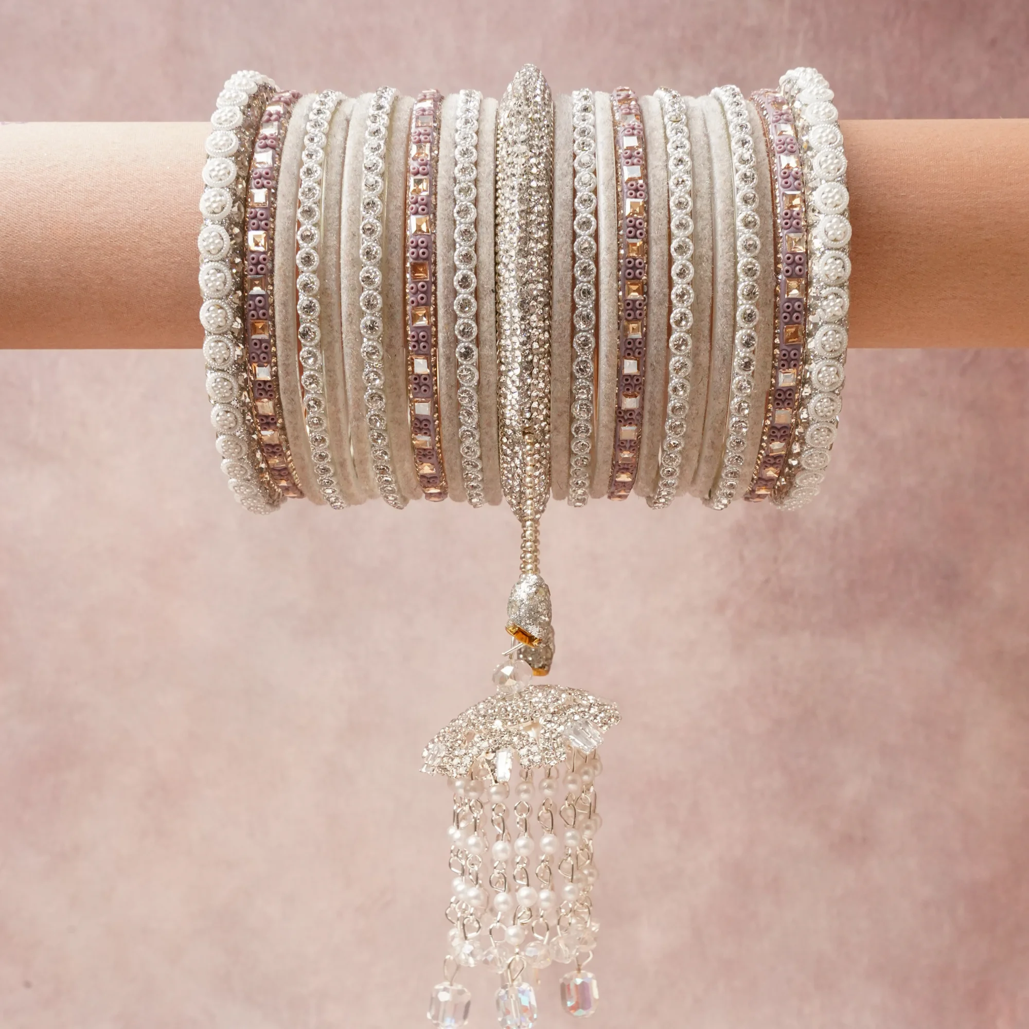 A commanding Silver White anchors this beautiful set, enriched with accents of Pale Rose Pink, Iridescent Pearl that add depth and dimension.

Featuring a striking composition of Silver-toned Metal, Clear Cubic Zirconia, Rose Pink Cubic Zirconia, Faux Pearls, Crystal Glass, Matte Composite Bangle Base, this set carries intricate craftsmanship and strong presence. Grand in form, it is created for moments that deserve to be marked.